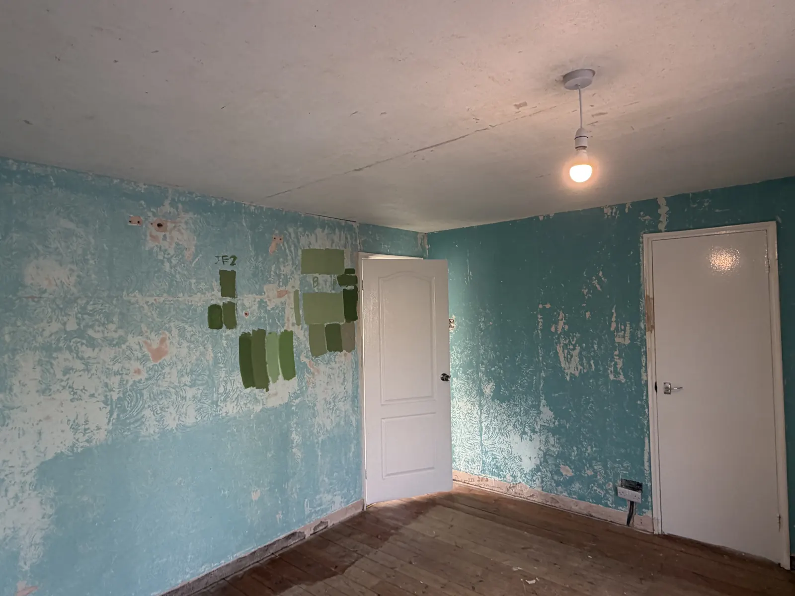 Bedroom corner in Allestree with worn, uneven wall surfaces beside the bedroom and cupboard doors