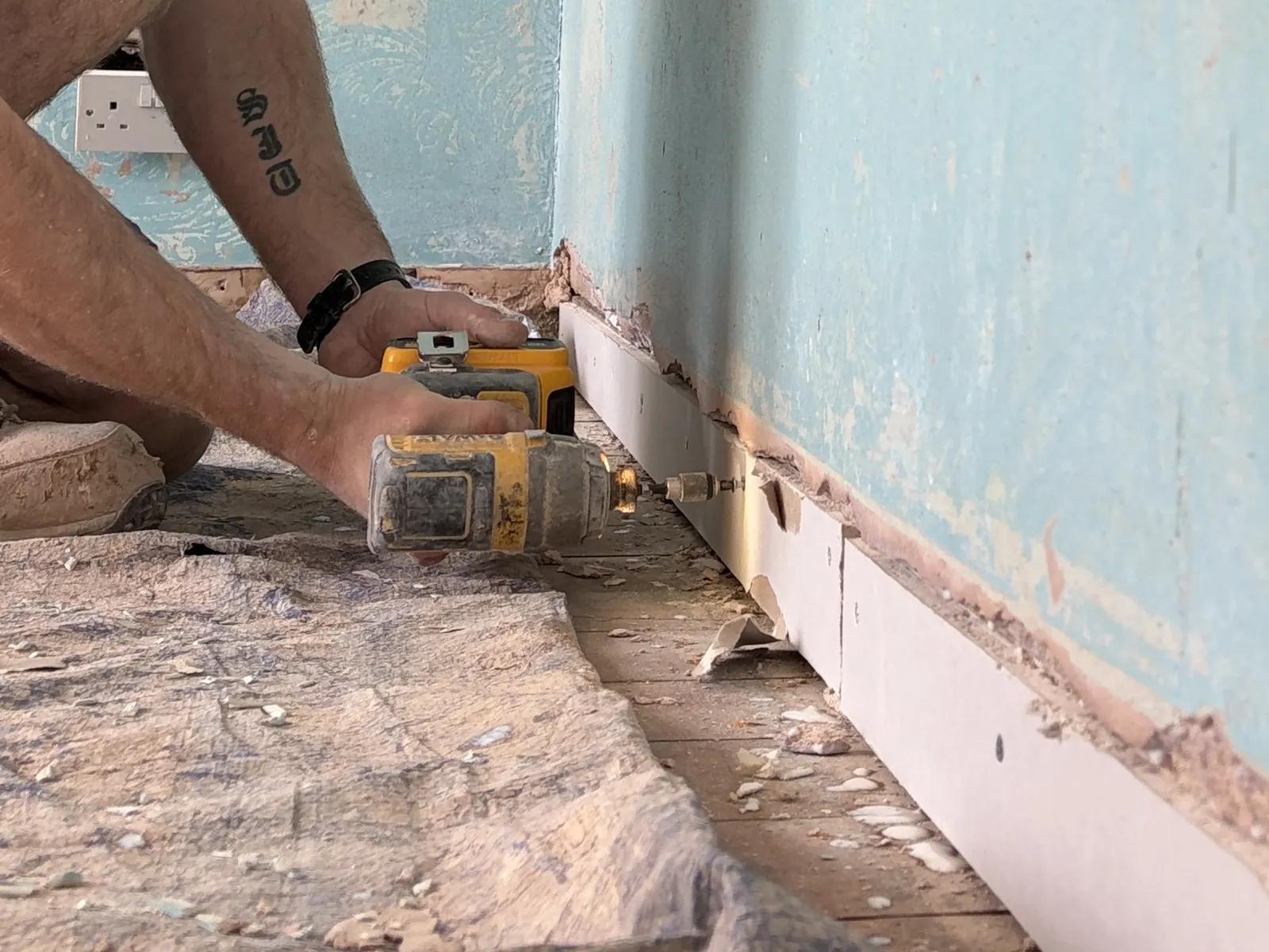 Plasterer building out the skirting line along the base of the bedroom wall