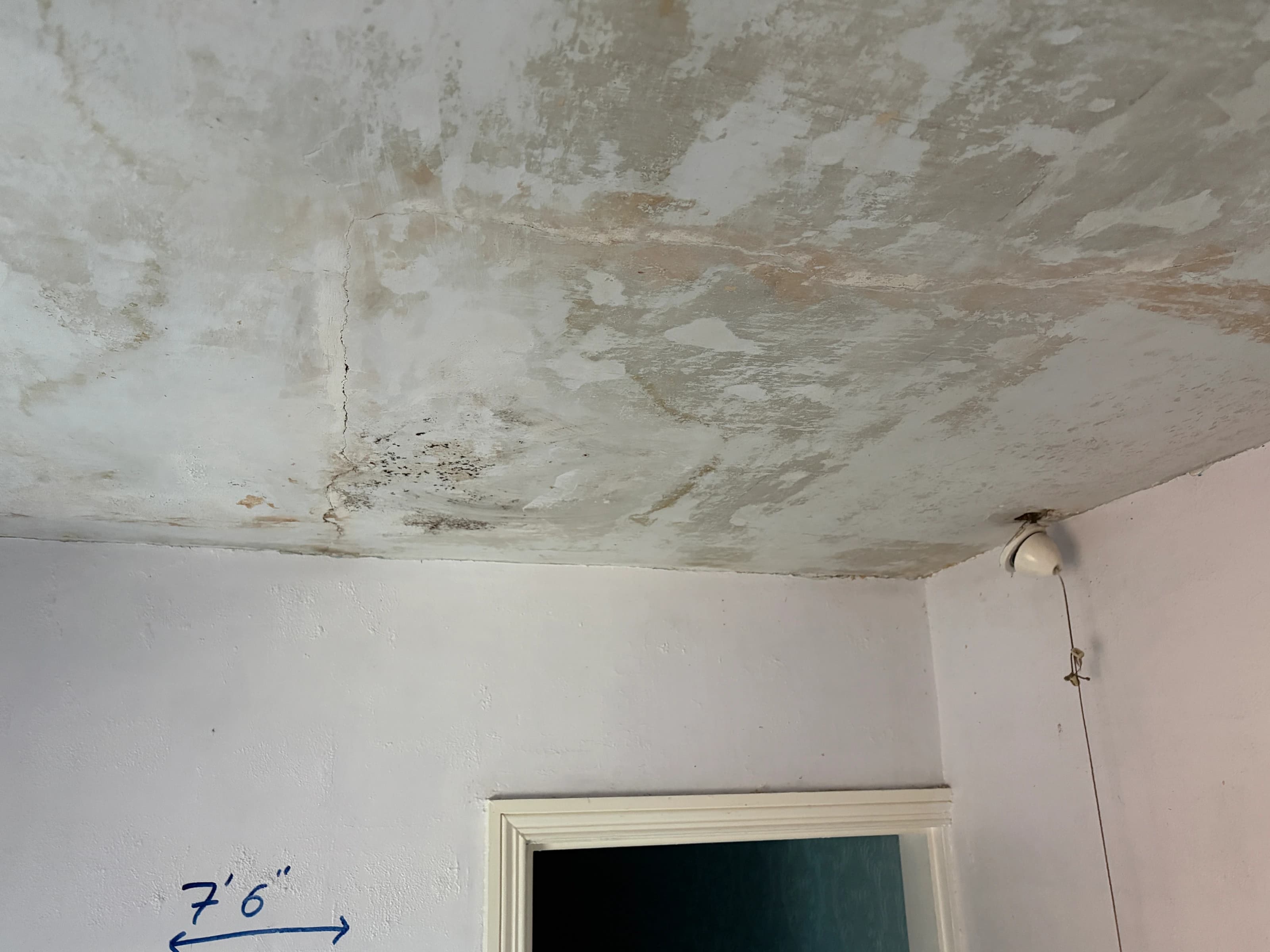 Cracking and patchy original ceiling surfaces above the doorway in the Alvaston bedroom