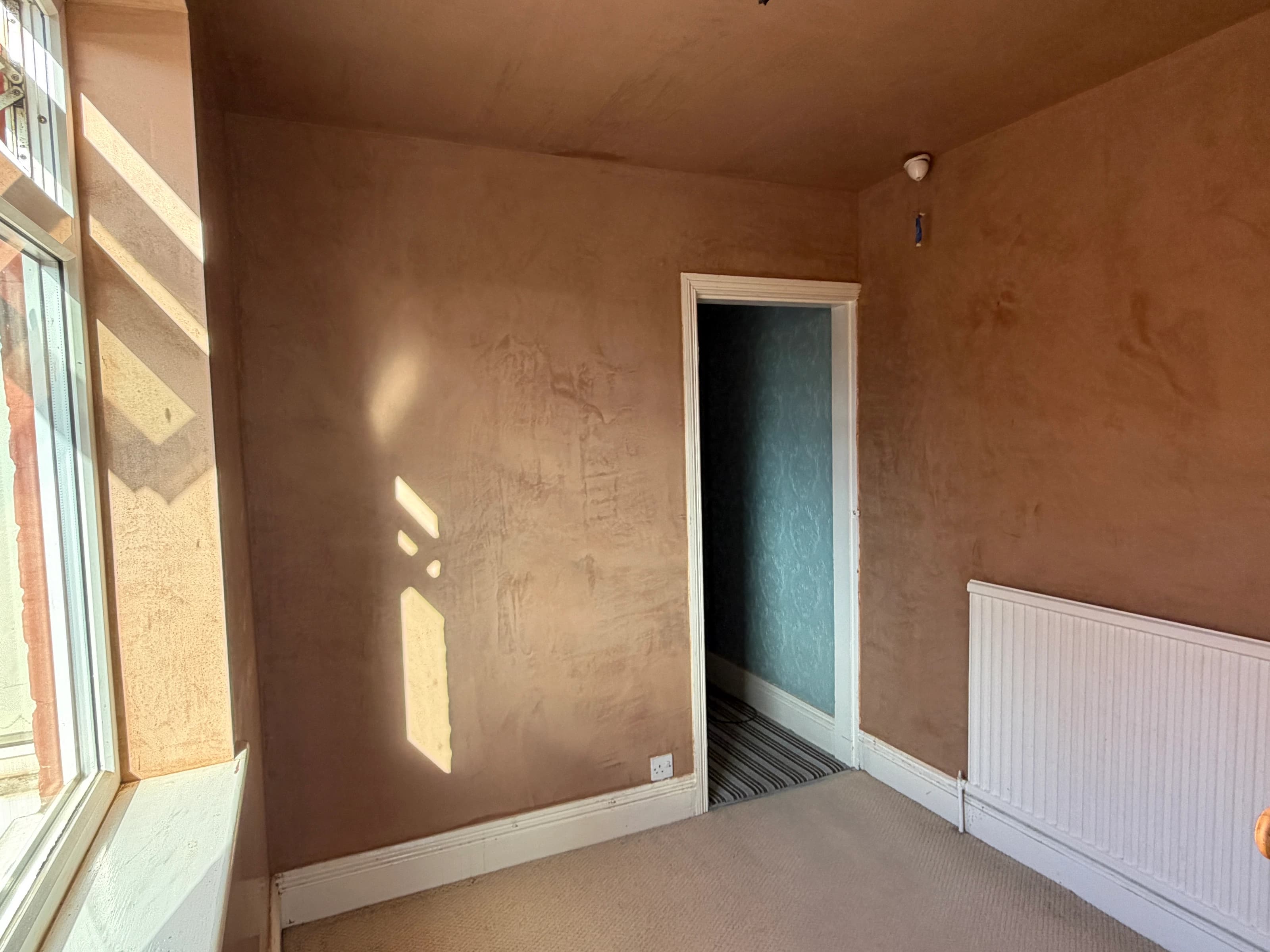 Freshly skimmed bedroom walls and ceiling around the doorway and radiator in Alvaston