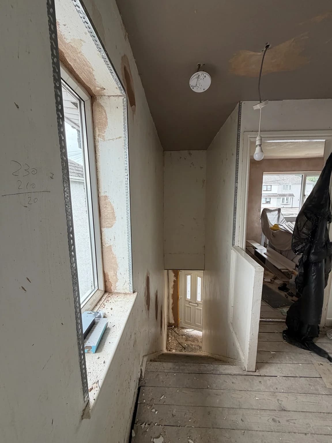 Hallway with damaged and uneven walls before plastering