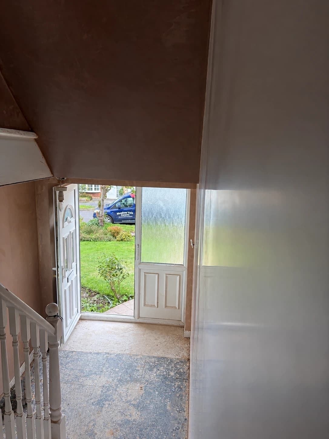 Fresh plaster across a stairwell and entrance hall, viewed from the stairs