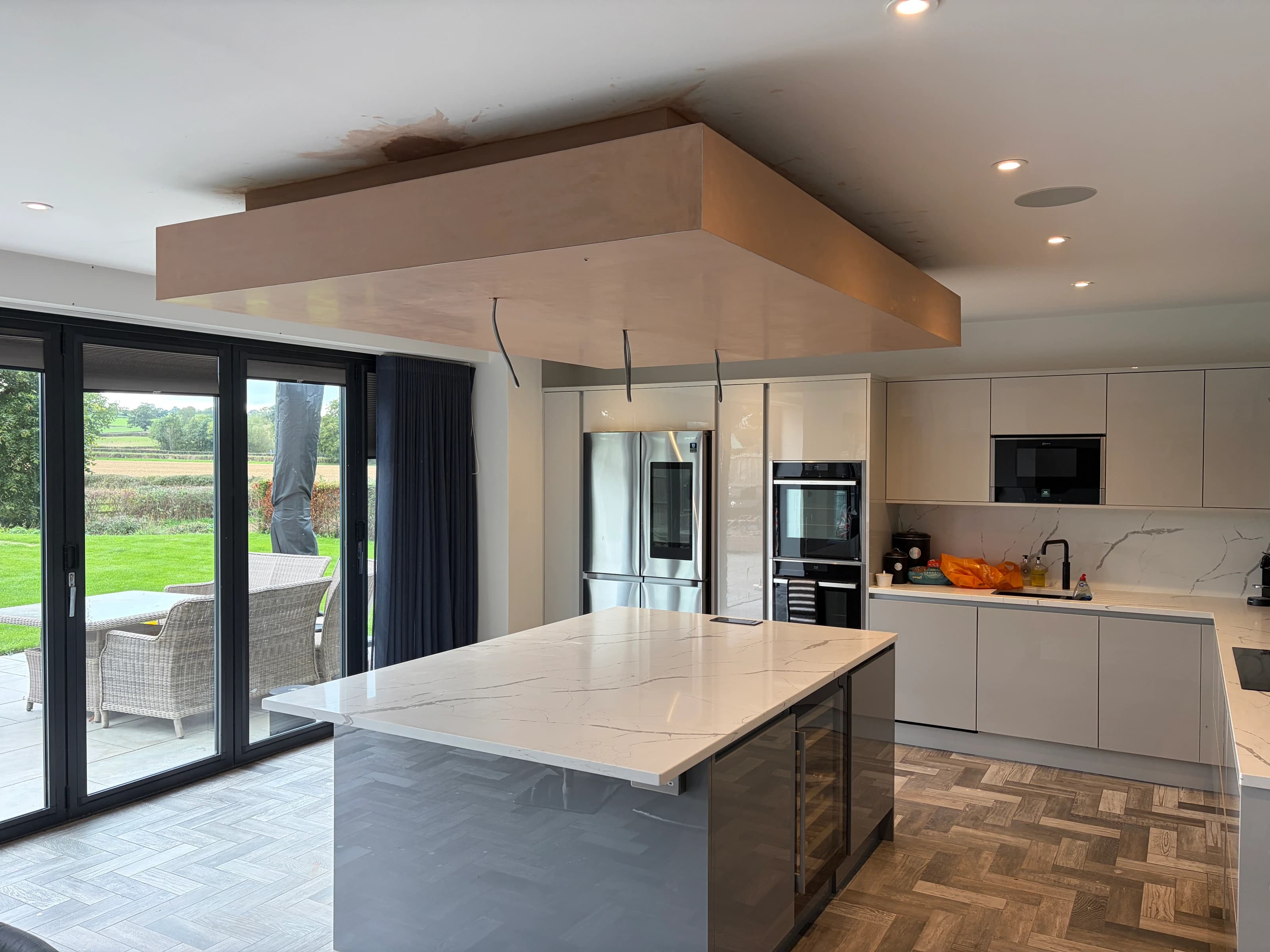 Freshly plastered suspended ceiling feature above a kitchen island